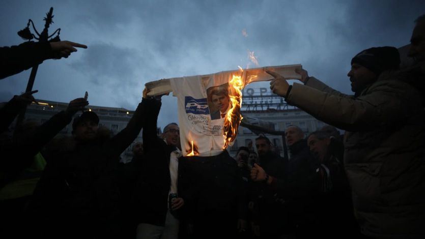 Los taxistas queman una camiseta con la imagen de Ángel Garrido frente a la sede del Gobierno madrileño.
