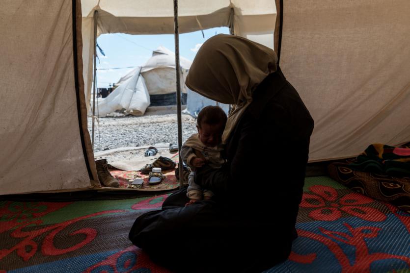 Hawa, 25 años, tiene en brazos a su hijo de 5 meses en una tienda del campo de desplazados de Salamiya. Su marido trabajó en una oficina del ISIS y fue asesinado en 2017.