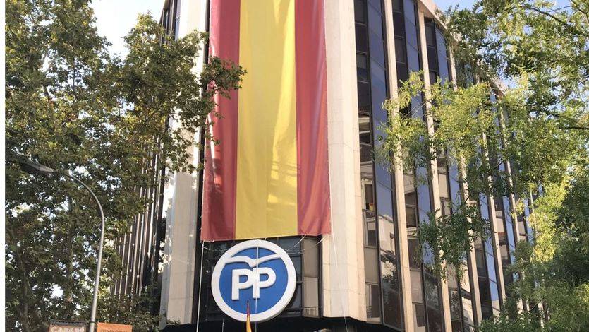 El PP cubre su sede con una enorme bandera de España