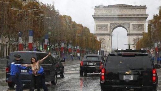 Una activista de Femen intenta abalanzarse sobre el coche de Trump durante la celebración del Armisticio