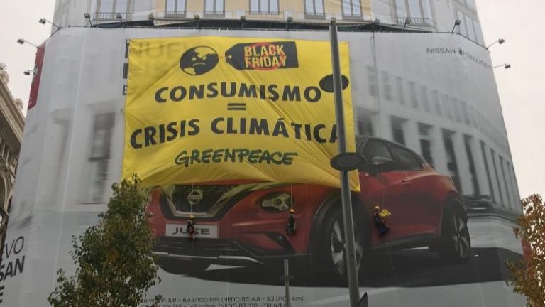 Greenpeace despliega una gran pancarta en plena Gran Vía contra el Black Friday y el consumismo