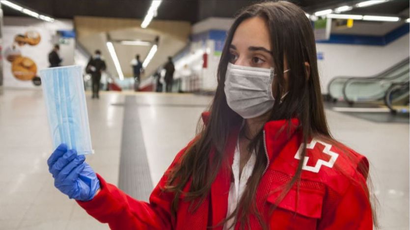 Voluntarios de la Cruz Roja reparten mascarillas en el Metro