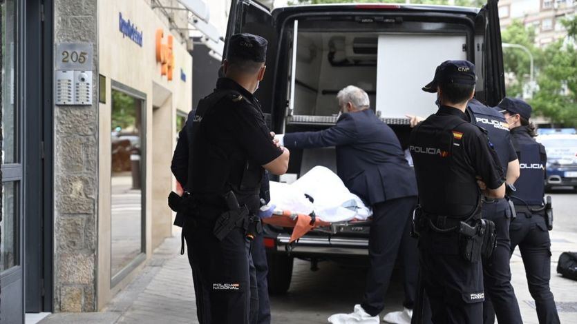 Momento en el que los servicios funerarios trasladan los cadáveres hallados en la vivienda de la calle Serrano