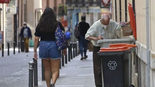 Un anciano busca comida en la basura en Madrid