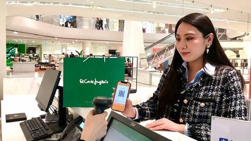 Mujer asiática comprando a través de Alipay en El Corte Inglés