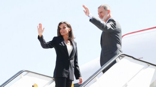 Los reyes Felipe y Letizia saludan desde la escalera del avión