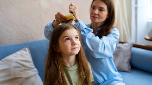 Madre quitando piojos a su hija
