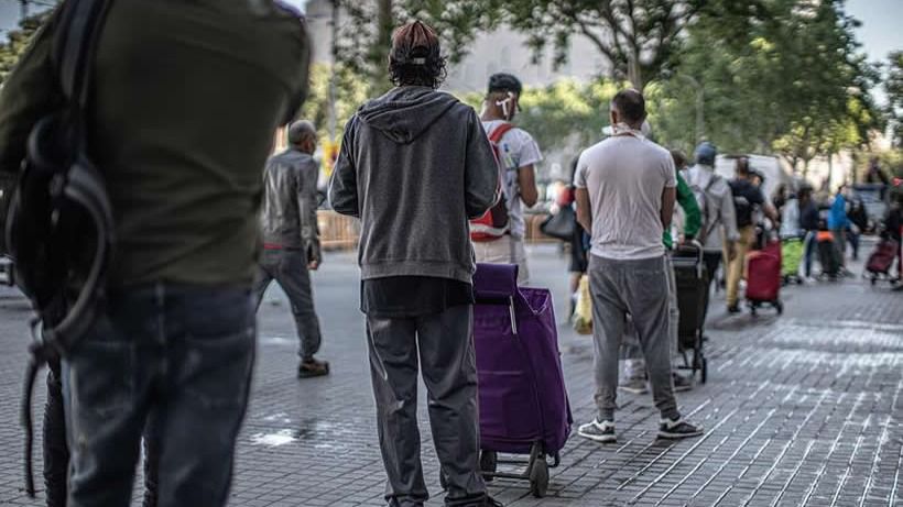 Personas en una cola de un comedor social