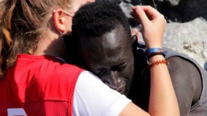 Abdou, refugiado senegales con una voluntaria de Cruz Roja