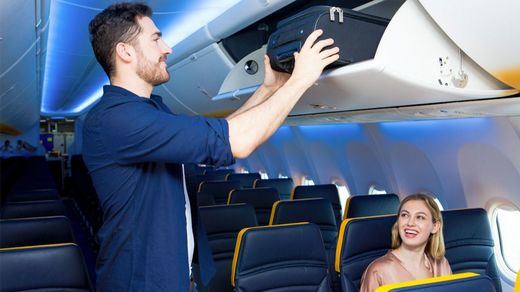Parajero guardando su maleta en el compartimento del avión