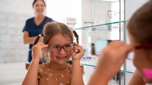 Una niña probándose gafas en una óptica