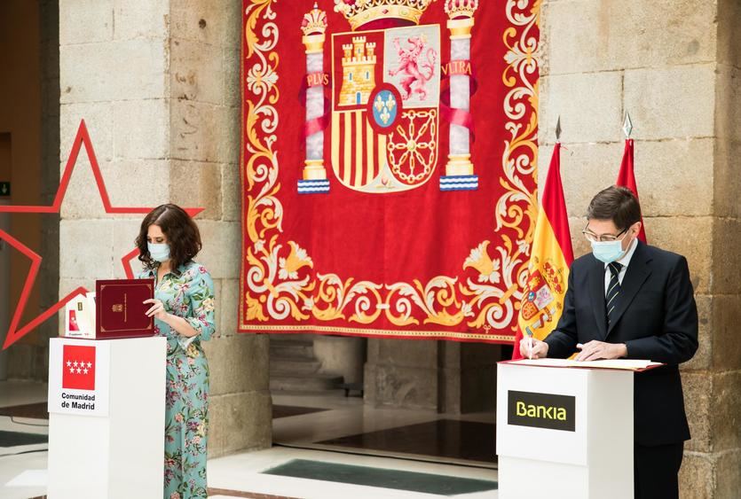 La presidenta de la Comunidad de Madrid, Isabel Díaz Ayuso; y el presidente de Bankia, José Ignacio Goirigolzarri, durante la firma del acuerdo del Carné Joven