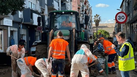 Voluntarios y efectivos municipales realizando labores de limpieza en las calles