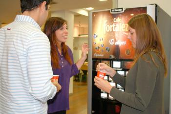 Un grupo de jóvenes toma café en una máquina de vending con cápsulas de Café Fortaleza