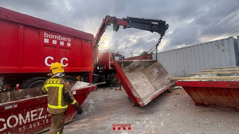 Bomberos echando los residuos del incendio de Vilanova en contenedores que después serán sellados