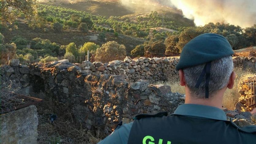 Un agente de la Guardia Civil vigilando el fuego de un incendio