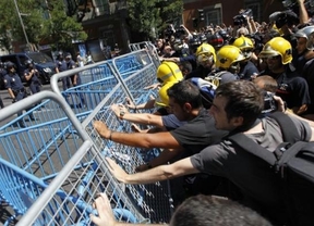 Los bomberos indignados tiran las vallas del Congreso a empujones

