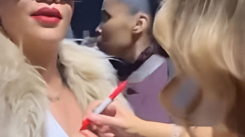 Rihanna dejándose firmar un pecho por Mariah Carey