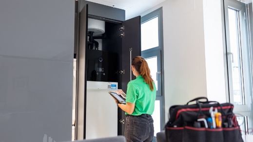 Técnico de Iberdrola ante la unidad interior de aerotermia en una vivienda