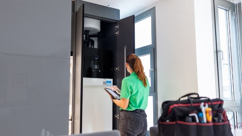 Técnico de Iberdrola ante la unidad interior de aerotermia en una vivienda
